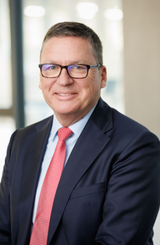 Picture showing Claus Moehlenkamp, Deputy CEO of the Freudenberg Group, wearing a dark suit and a red tie.