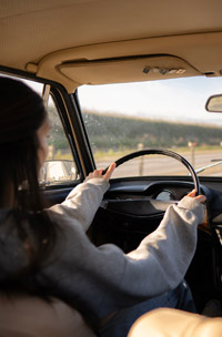a woman from behind driving a car