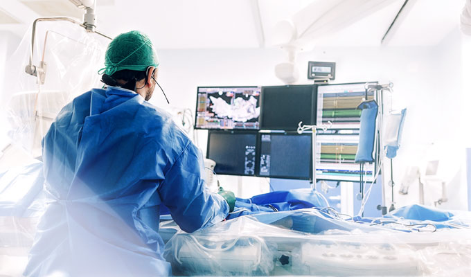 Doctor in an operating room performing an examination and looking at monitors