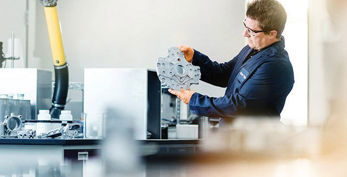 Man in overall checking a die casted part