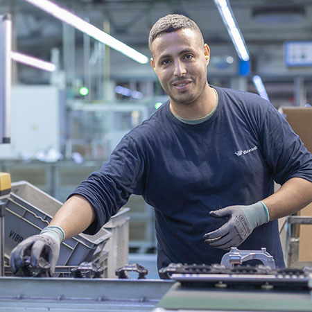 Photo shows a production employee looking friendly into the camera