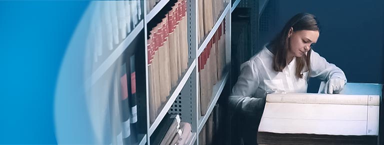 Young archivist researches historical book from the company archive