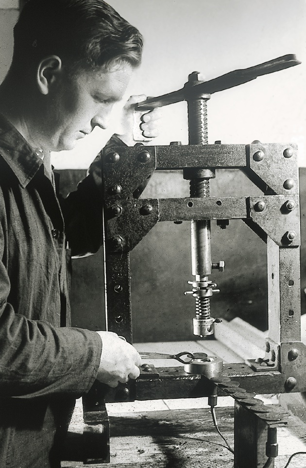 Picture shows a man who is operating a spindle press