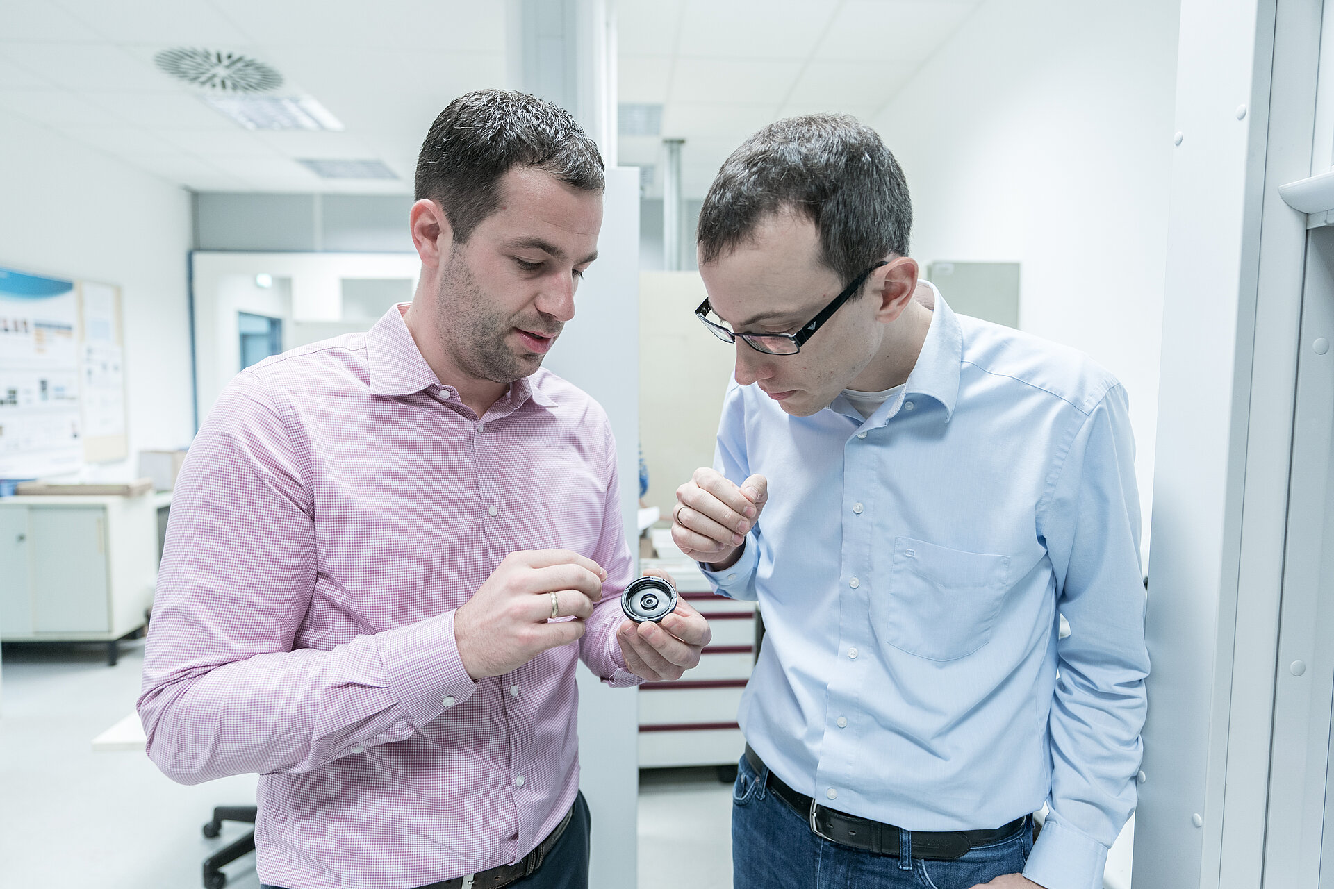 Dr. Fabian Kaiser explains his new job in the tribology laboratory to Dr. Neuberger.