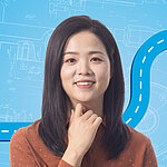 Portrait of a female person shown in the center of the picture against a blue background.