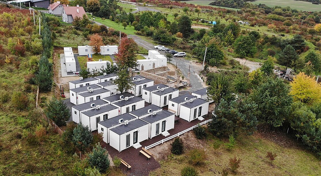 Bird's eye view of bungalows surrounded by meadows and trees