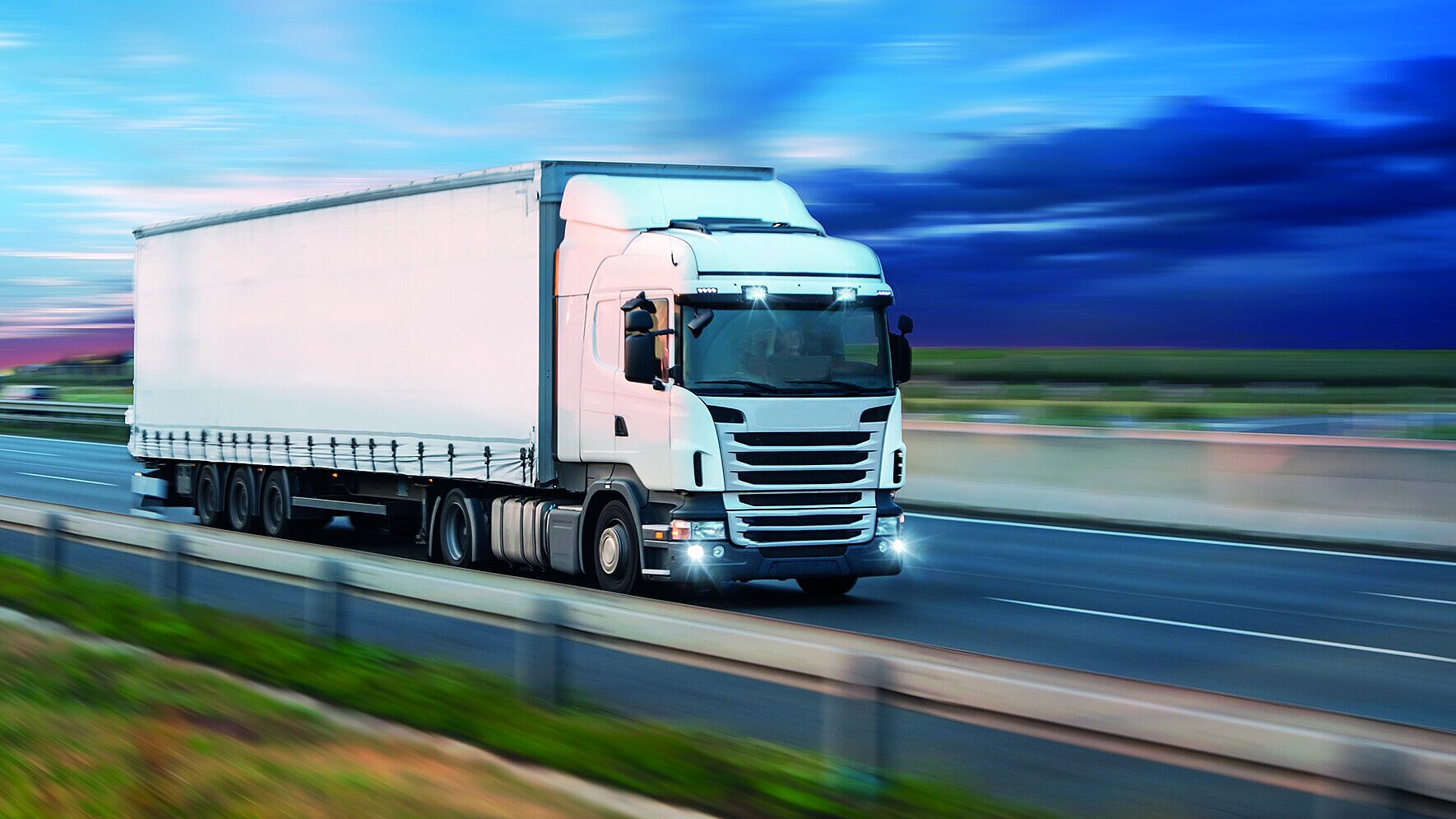 a truck in motion, driving on a highway