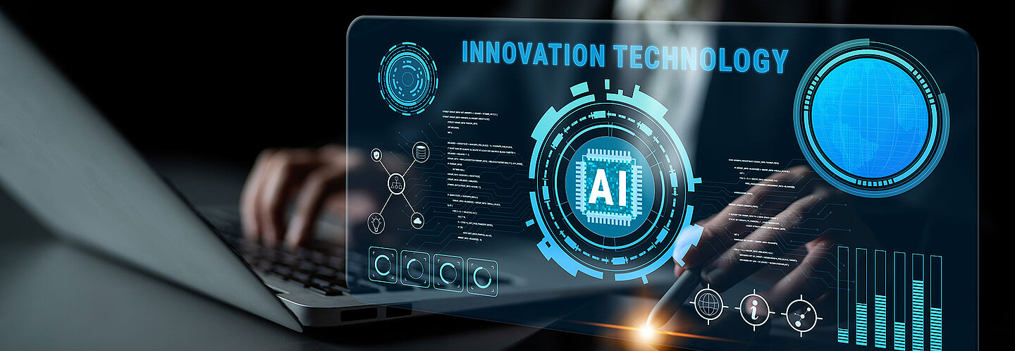 Detail von Laptop und Mousepen. Darüber liegt ein virtueller Screen mit Diagrammen und der Integration von KI in der Entwicklung und Prozessen hinweist