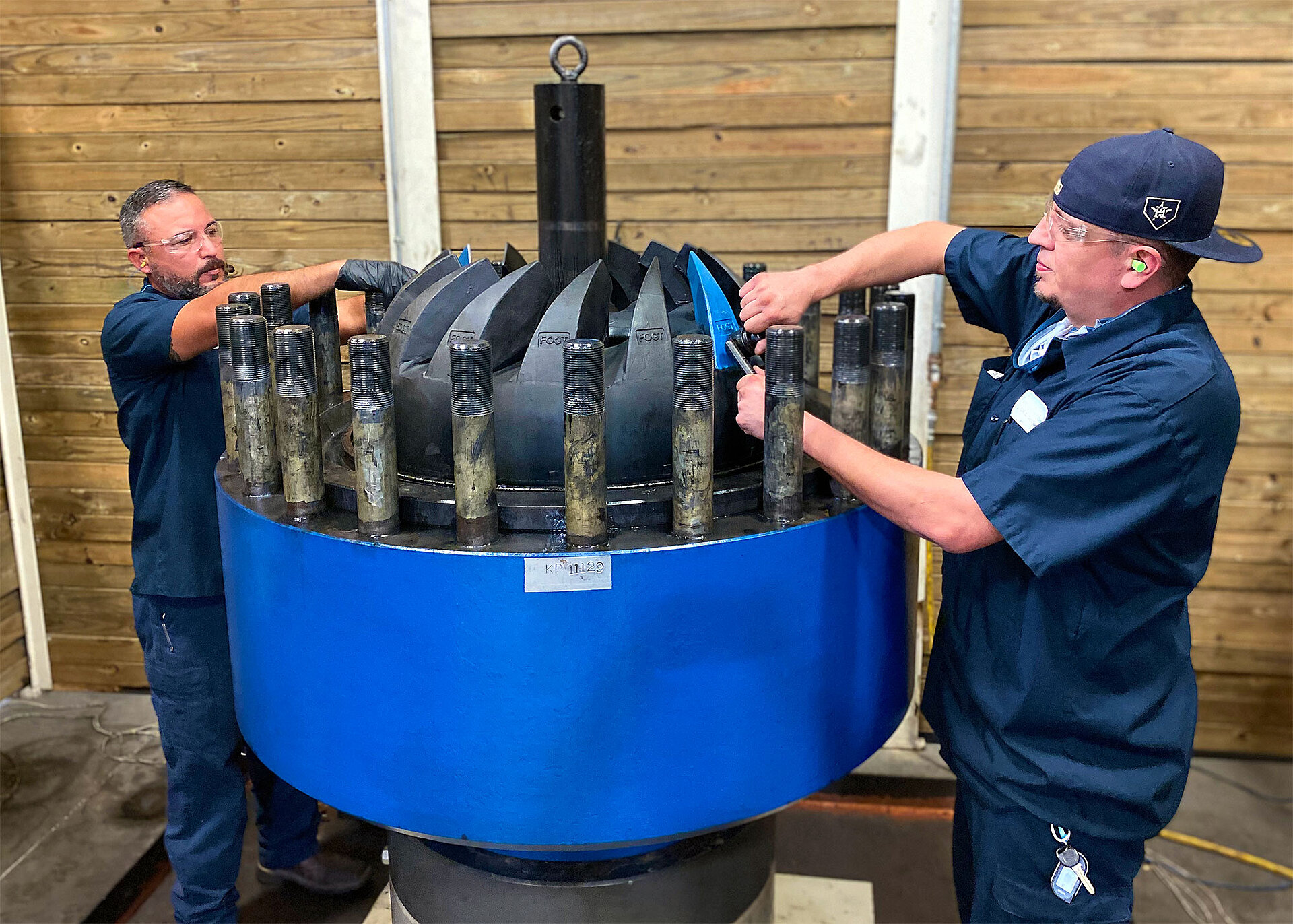 two technicians position the so called "Ultra Annular" sealing element  into a spherical assembly.