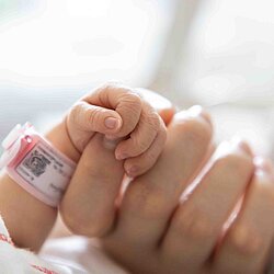 a mother holding her baby's hand