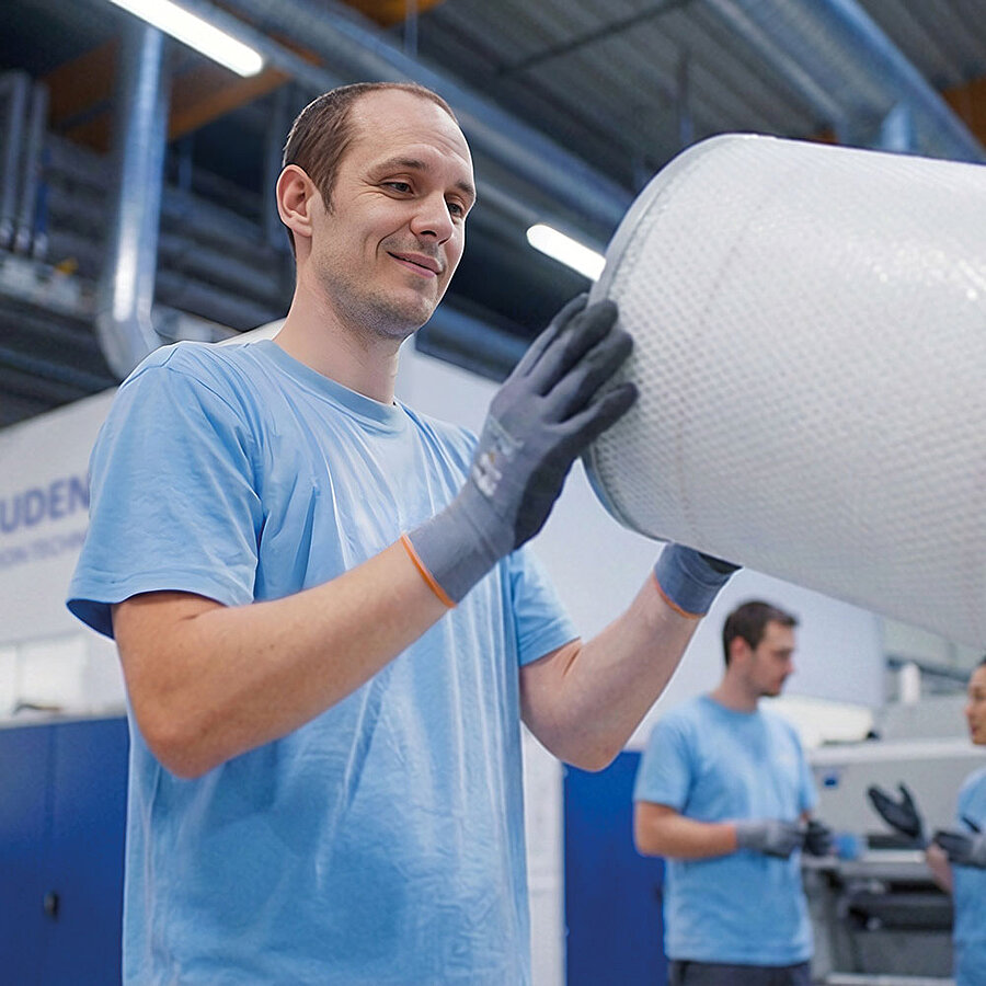 Worker in a production environment inspecting a filter.