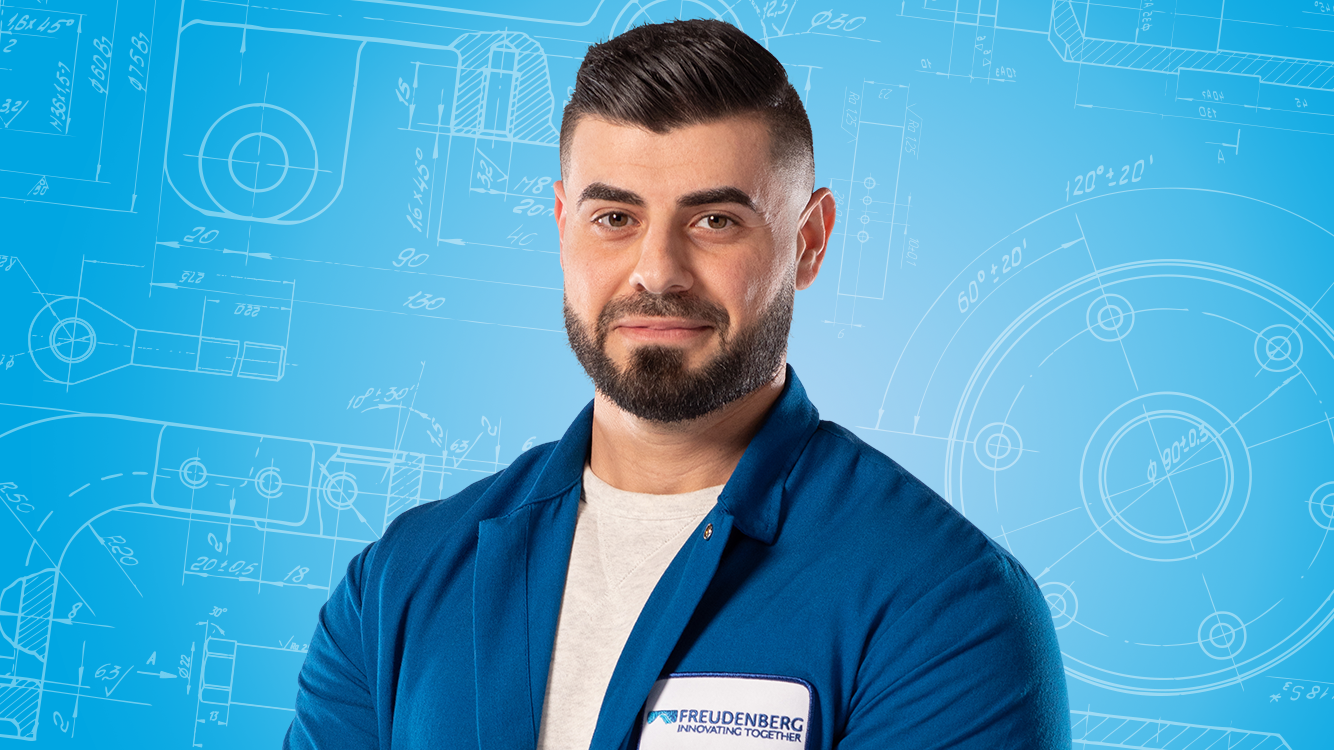 Portrait of a male person shown in the center of the picture against a blue background.