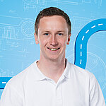 Portrait of a male person shown in the center of the picture against a blue background.