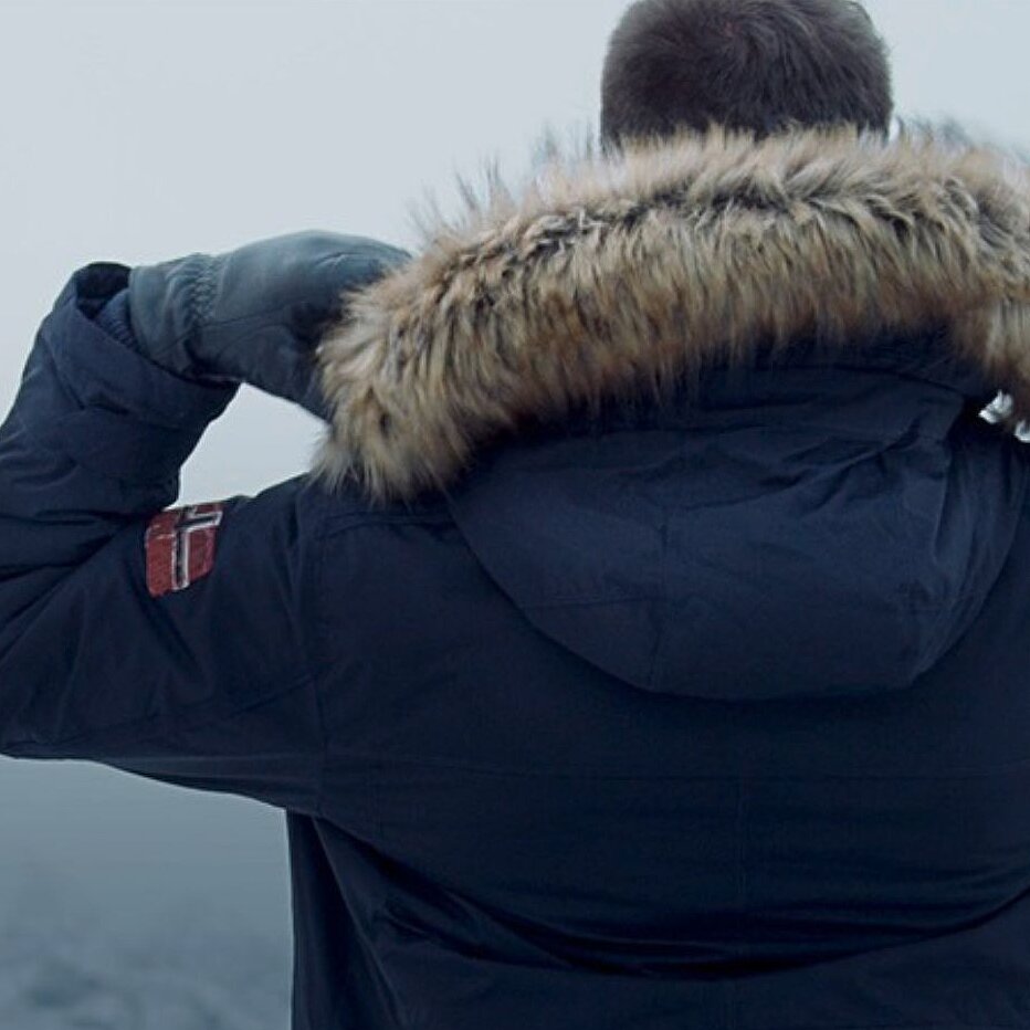 a man from behind, wearing a dark blue jacket 