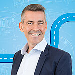 Portrait of a male person shown in the center of the picture against a blue background.