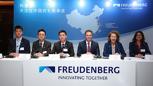 People sitting at the Freudenberg desk, one of them CEO Dr. Mohsen Sohi