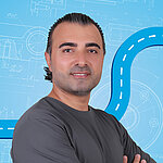 Portrait of a male person shown in the center of the picture against a blue background.