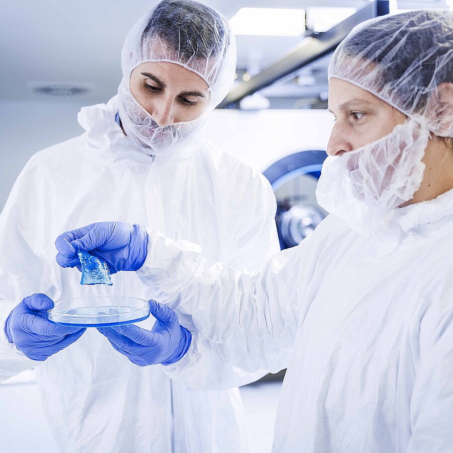 Two Freudenberg Performance Materials experts inspecting a product in a modern lab environment