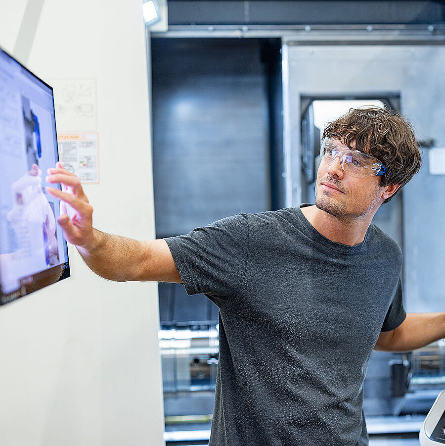 Young employee of Freudenberg Flow Technologies working in a modern production facility using touch screens