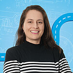 Portrait of a female person shown in the center of the picture against a blue background.