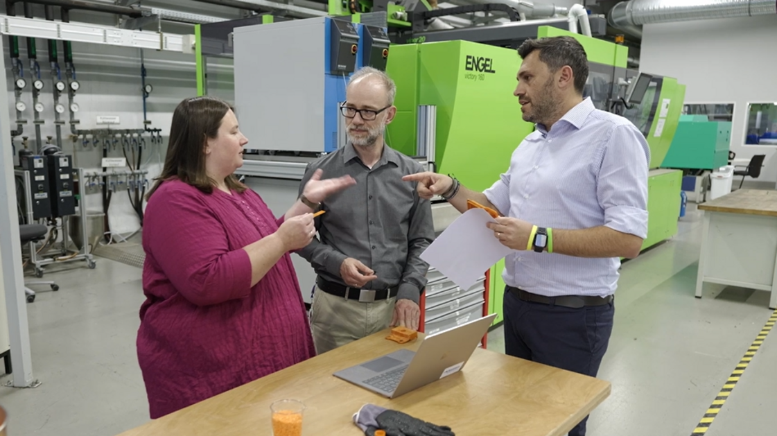 Two men and a woman standing together and talking to each other