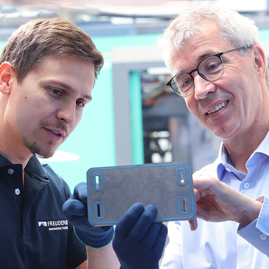 Freudenberg Sealing Technologies employees looking at a bipolar plate, fuel cell gasket, in a production facility
