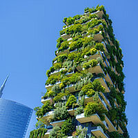 a tall buidling with a green facade full of plants