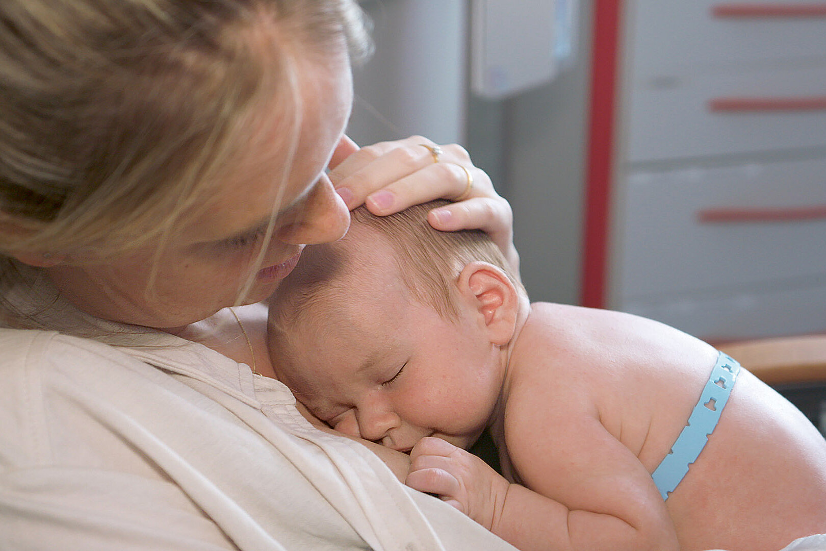 a mother hugs her premature baby that is wearing a blue BambiBelt