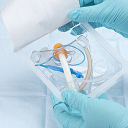 two hands with medical gloves holding an oxygen mask