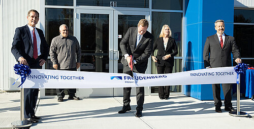 Man in the middle cuts a ribbon