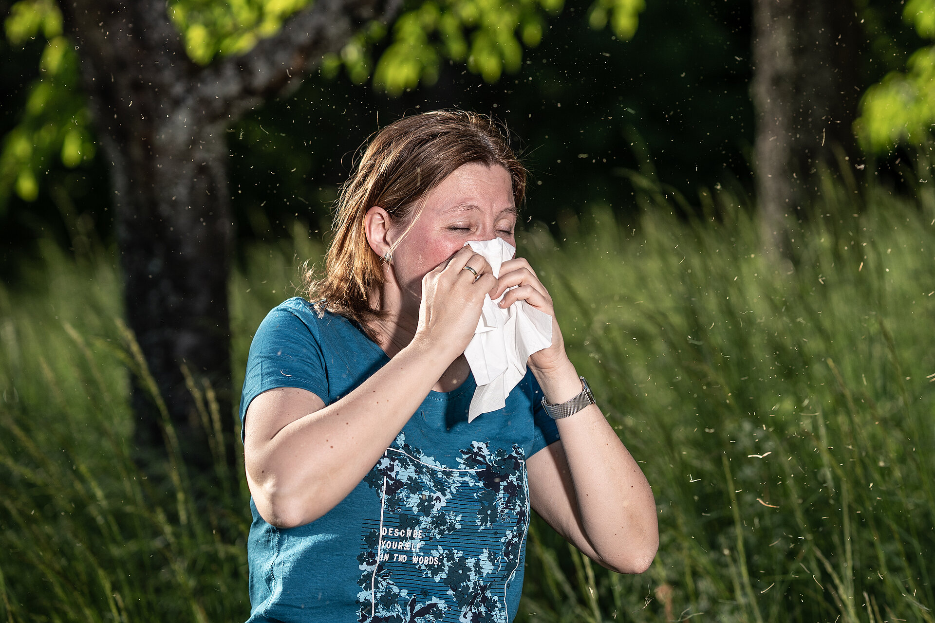 Woman sneezing because of allergy.