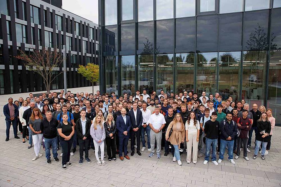 Das Bild zeigt eine Gruppe junger Menschen, die vor einem Gebäude steht