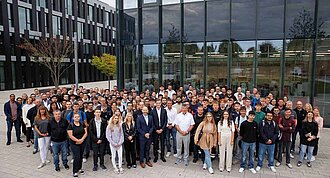 A large group of young people standing in front of a building