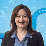 Portrait of a female person shown in the center of the picture against a blue background.
