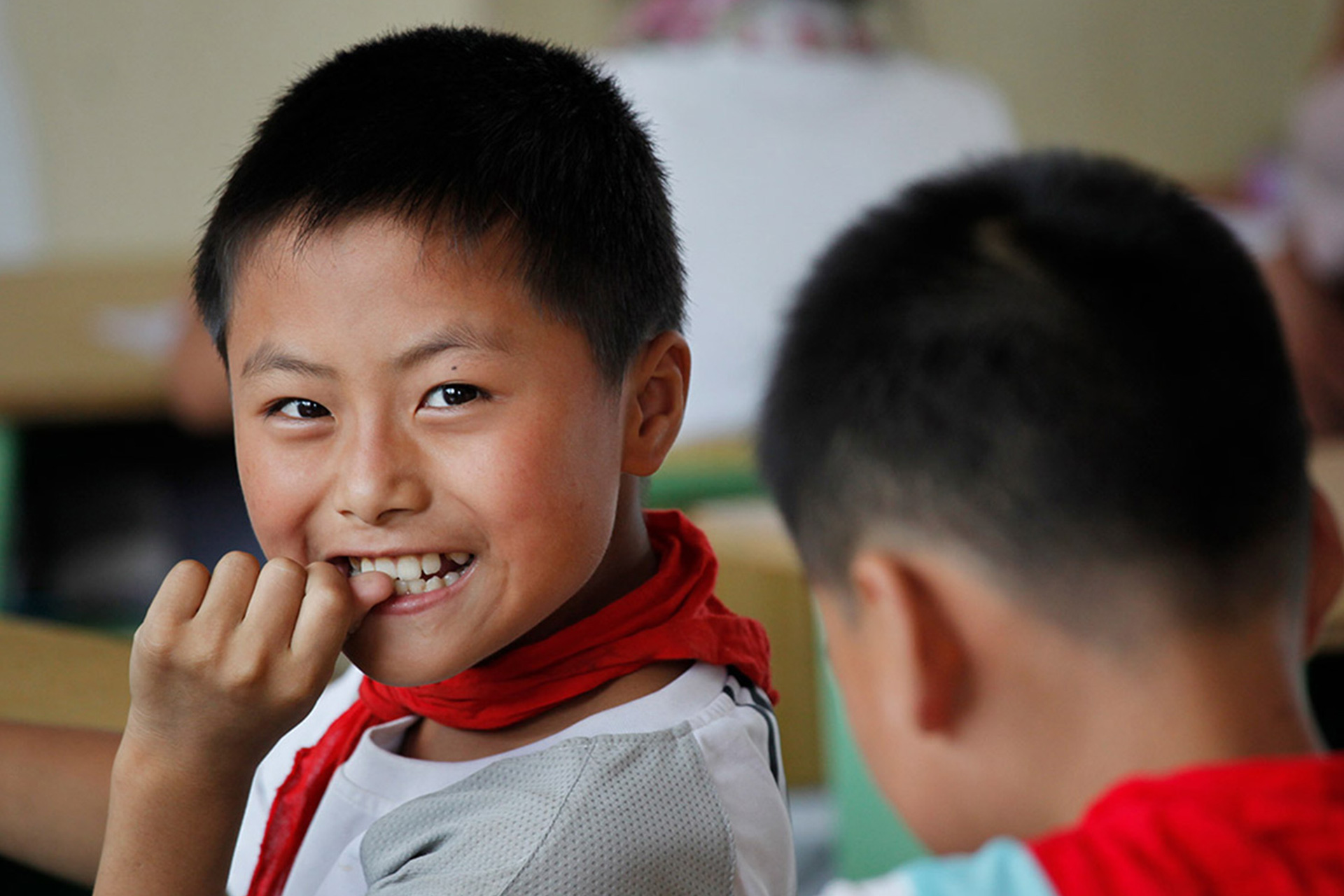 Portrait eines chinesischen Jungen, der in die Kamera lächelt
