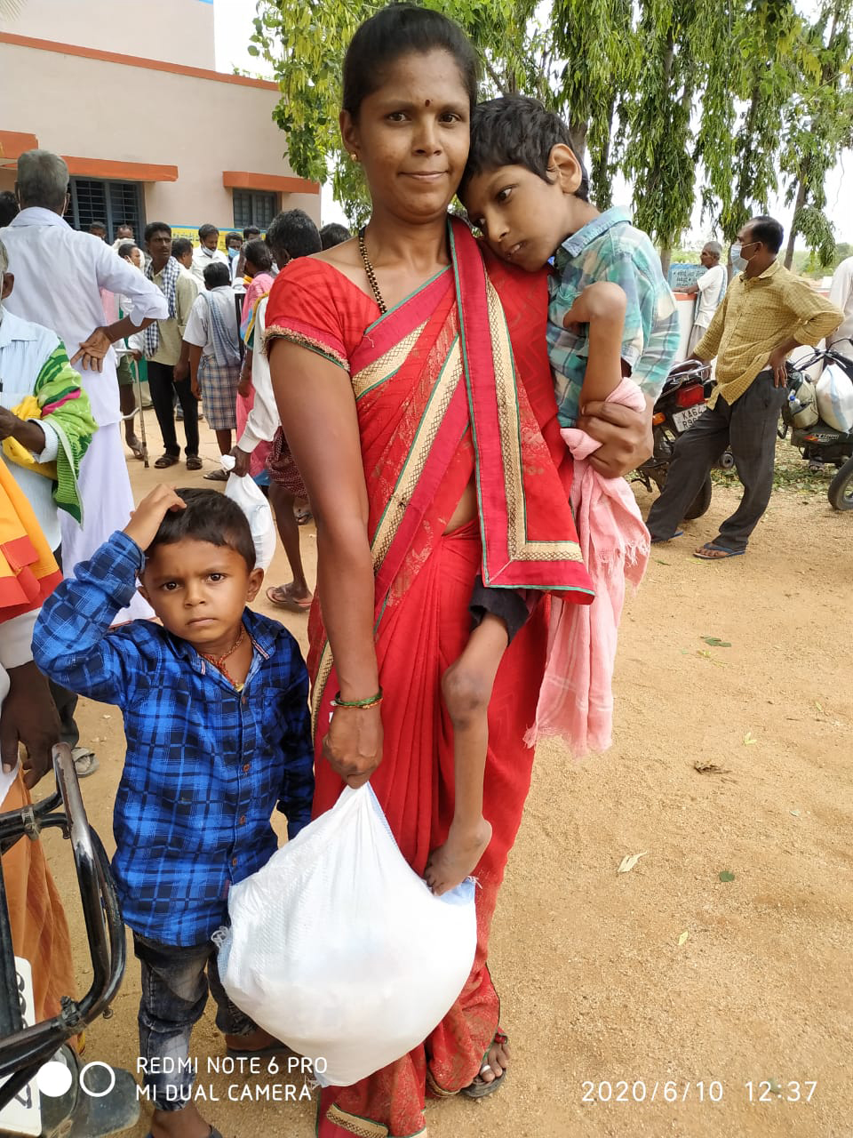 Indian mother and her two children receives a bag with food.