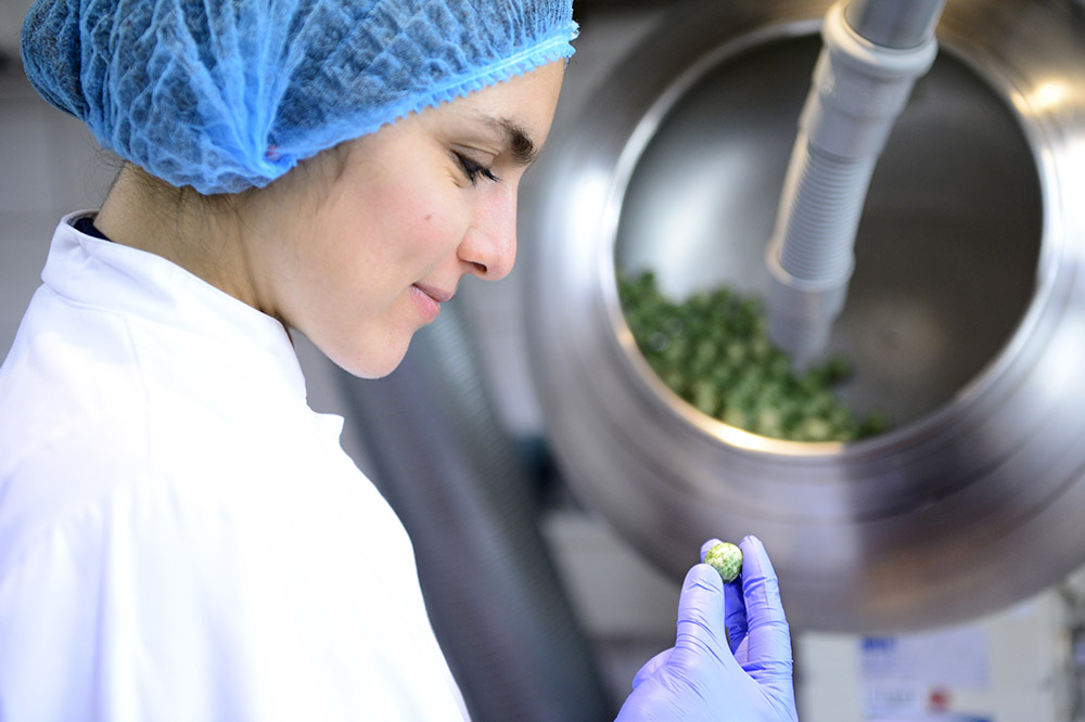 employee examining chocolate dragées